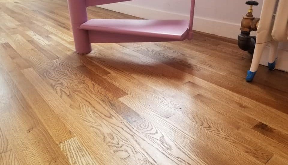 A pink chair in the corner of a room.