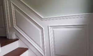 A close up of the corner of a room with white walls.