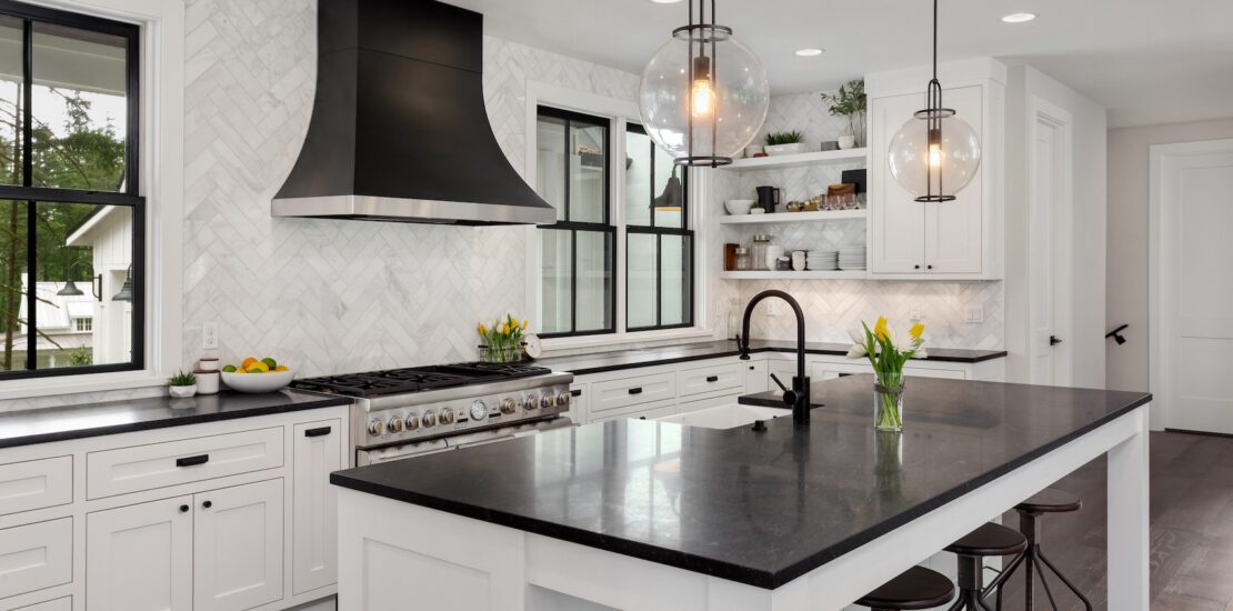 A kitchen with black and white decor, and an island.